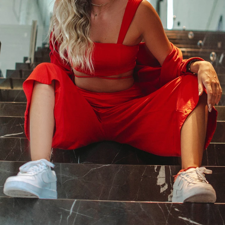 woman in red co-ord outfit sitting on stairs