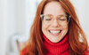 Woman with red jumper and hair smiling