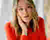 woman in red shirt staring into mirror