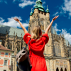 woman in front of big monument building in red dress with hands in the air
