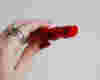 woman holding red lipstick, the image focuses on the red lipstick