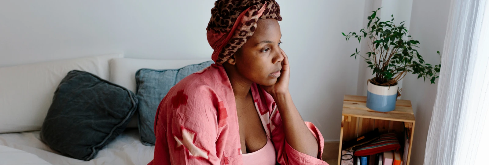 woman looking out of window looking sad/ concerned