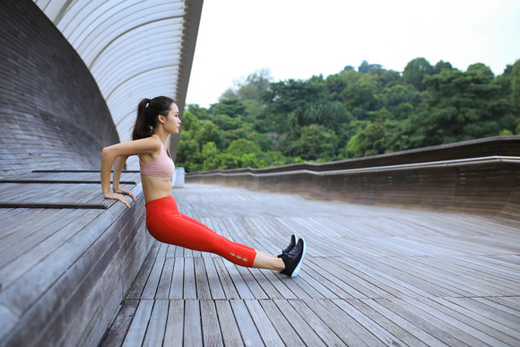 woman excersising whilst wearing work out clothes and noticeably wearing red leggings.