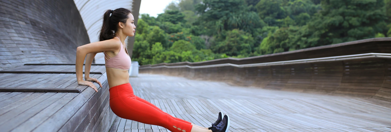 woman excersising whilst wearing work out clothes and noticeably wearing red leggings.