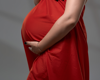 pregnant woman posing in flowy red dress