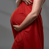 pregnant woman posing in flowy red dress