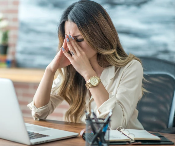 young woman sat at her laptop looking frustrated