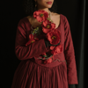 close shot of woman holding red flowers in a red dress