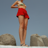 woman standing on rocks in red shorts
