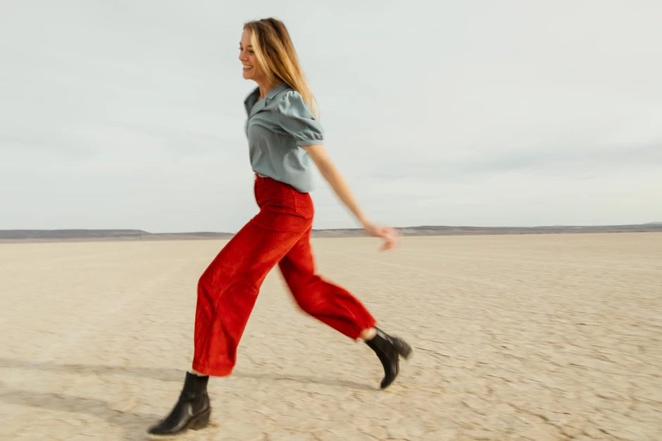 happy woman running wearing red trousers