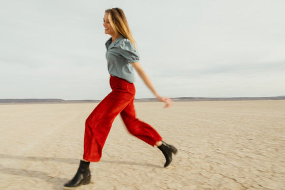 happy woman running wearing red trousers