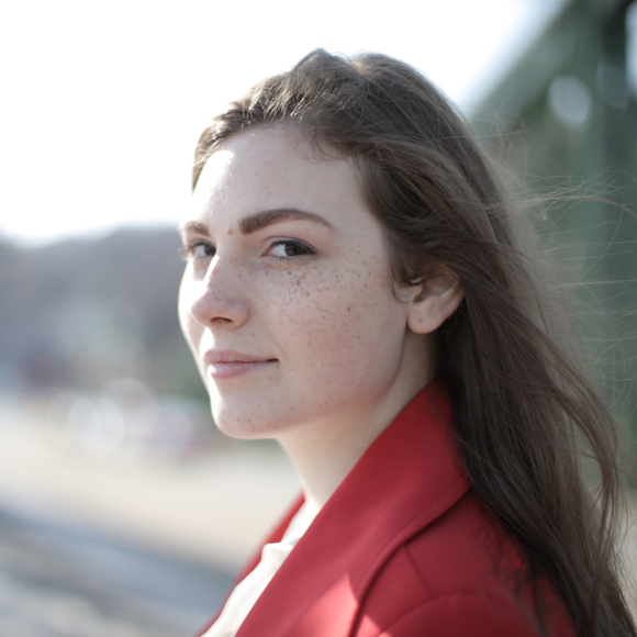 woman wearing a red blazer looking at the camera happily