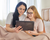 mother showing daughter something on a tablet