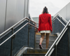 woman in red blazer walking up stairs away from camera