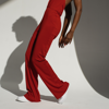 woman in red jumpsuit posing on white backdrop