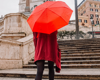 woman in red jacket holding red umbrella