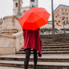 woman in red jacket holding red umbrella