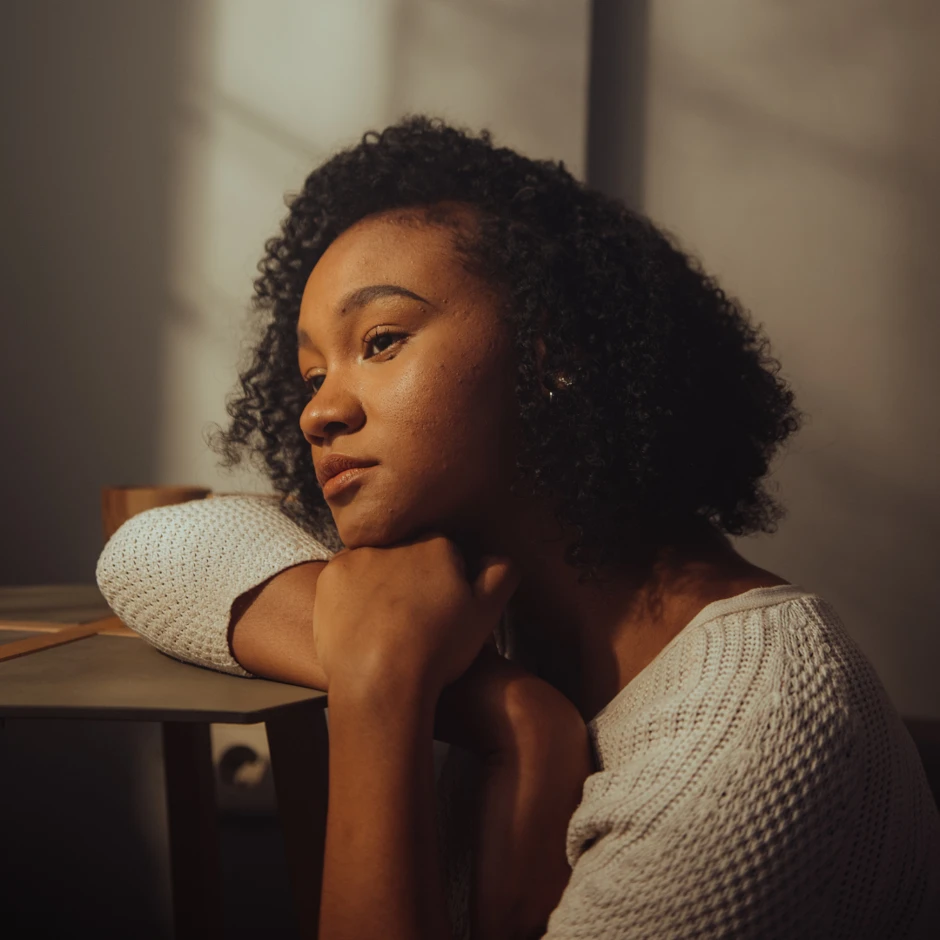 young woman at the desk, looking out the window