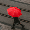 person walking holding red umbrella