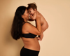 intimate shot of mother holding baby in the air smiling