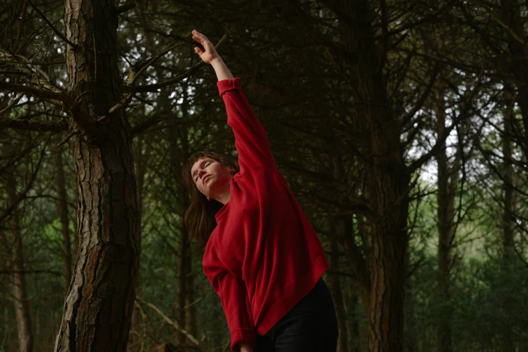 woman in red jumper stretching